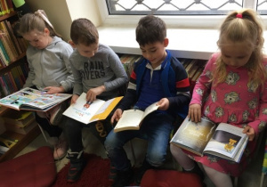 Czworo dzieci przegląda książeczki